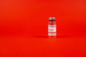 Vaccine vial on red background