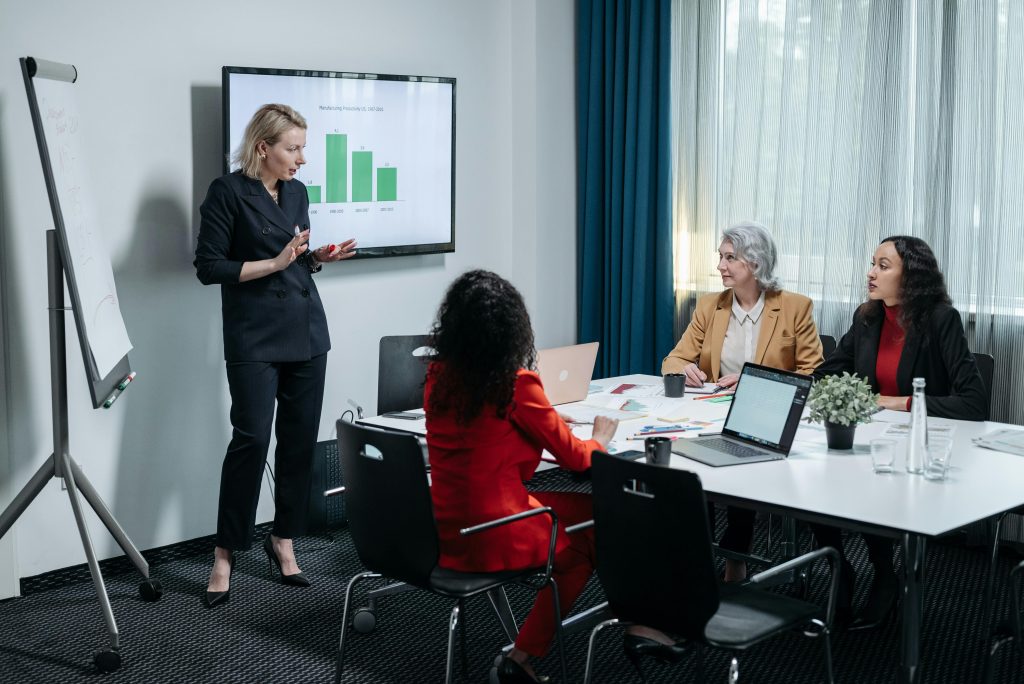 A woman presenting to a group of people in a conference room.